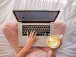 person using MacBook Pro and holding cappuccino title How to Balance SEO and Readability 